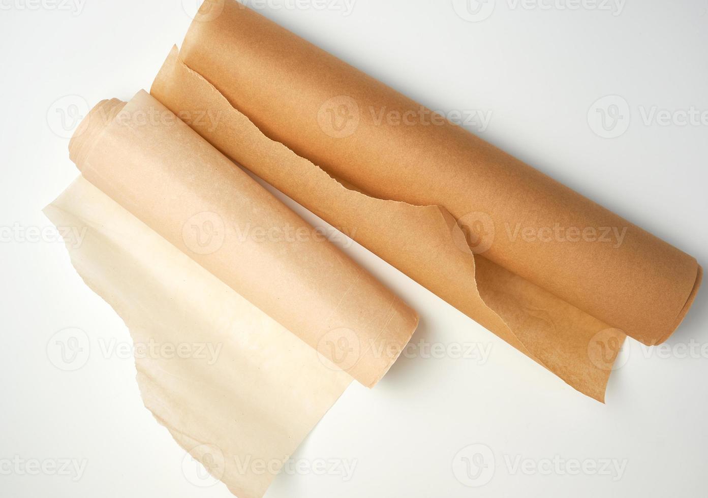 two rolls of brown parchment paper for baking on a white background photo