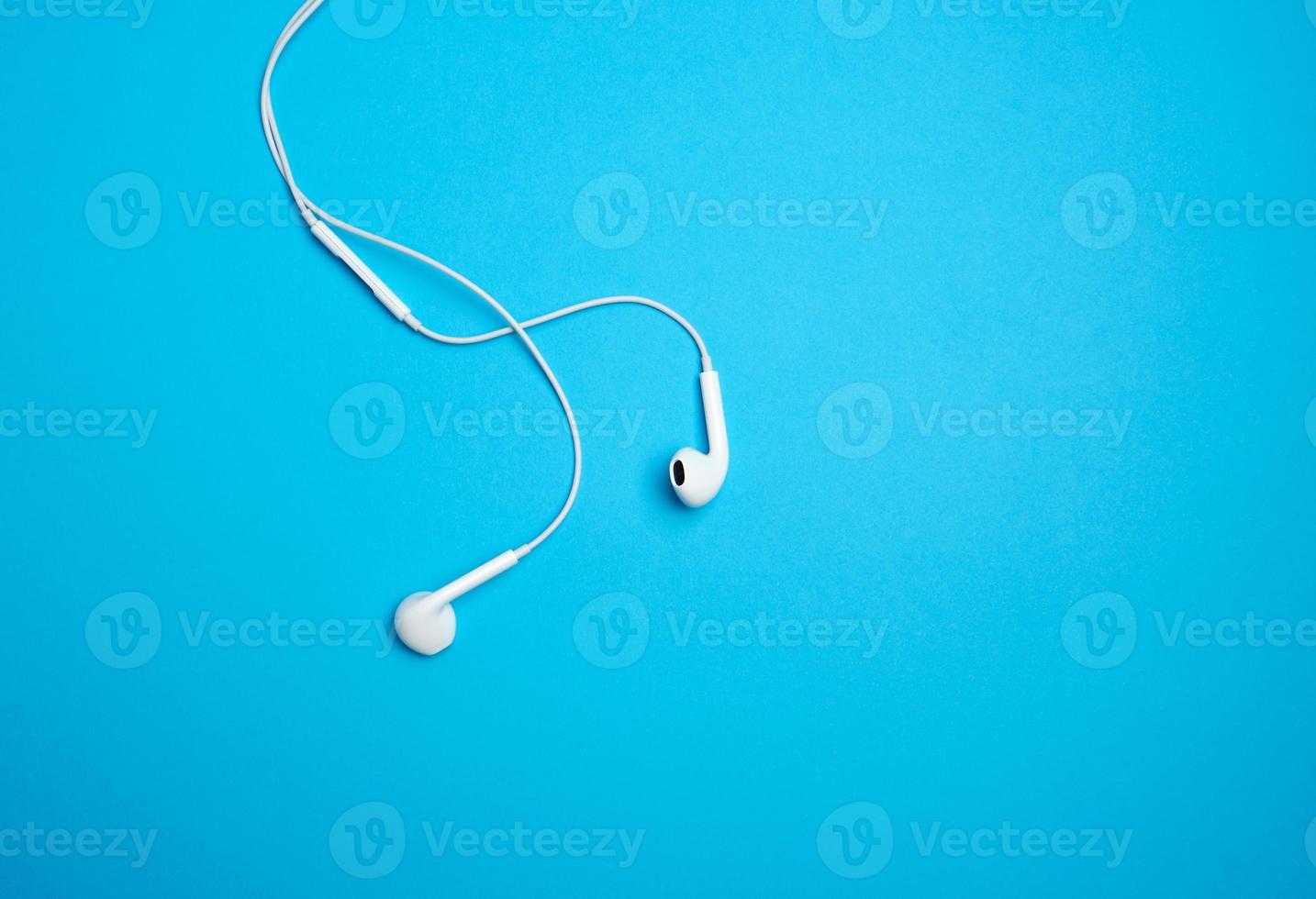 white earphones with a cable on a blue background photo