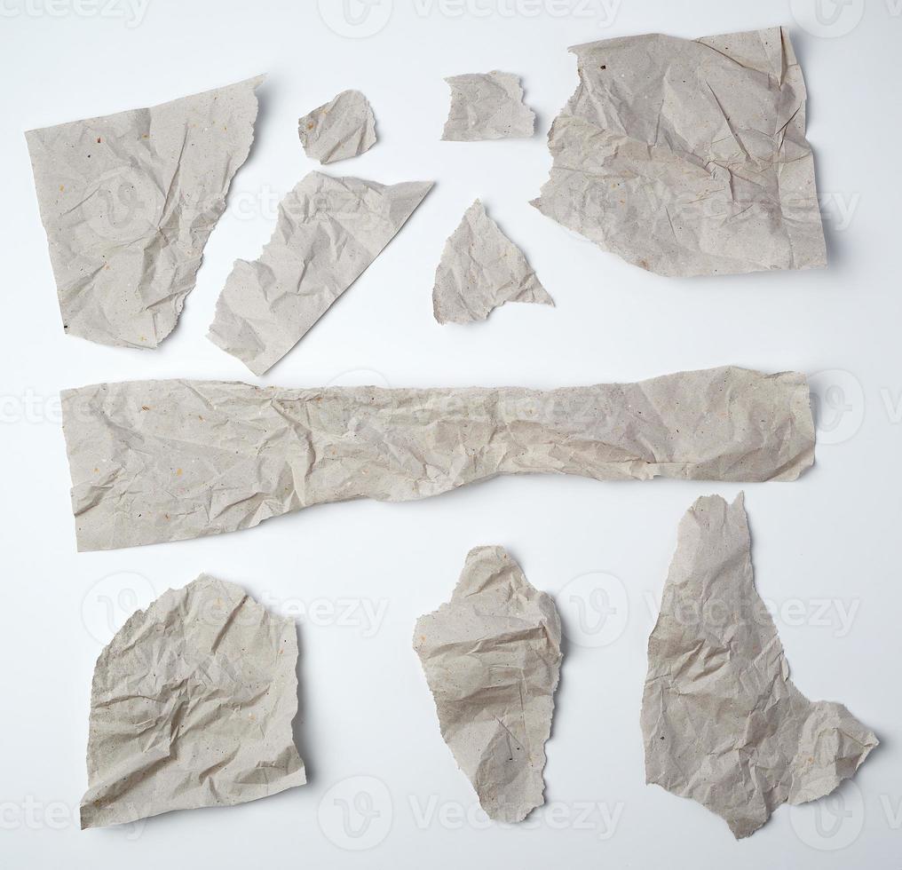 set of various pieces of torn gray crumpled paper on a white background photo