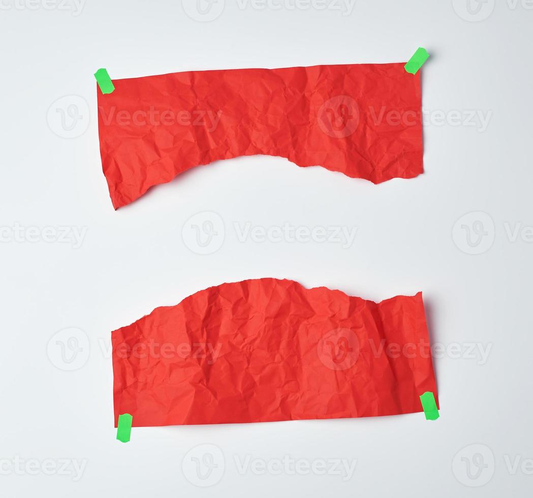 crumpled red sheet of A4 paper torn in half and glued with green sticky tape photo