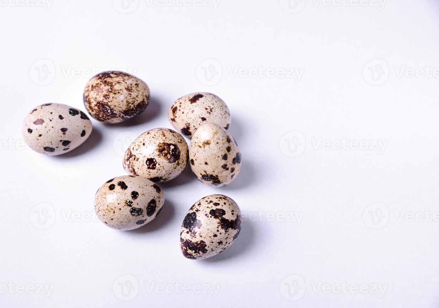 Group of quail eggs on a white surface photo