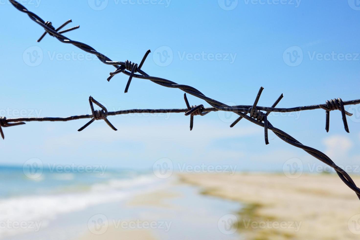 vallado de la orilla del mar con alambre de púas foto