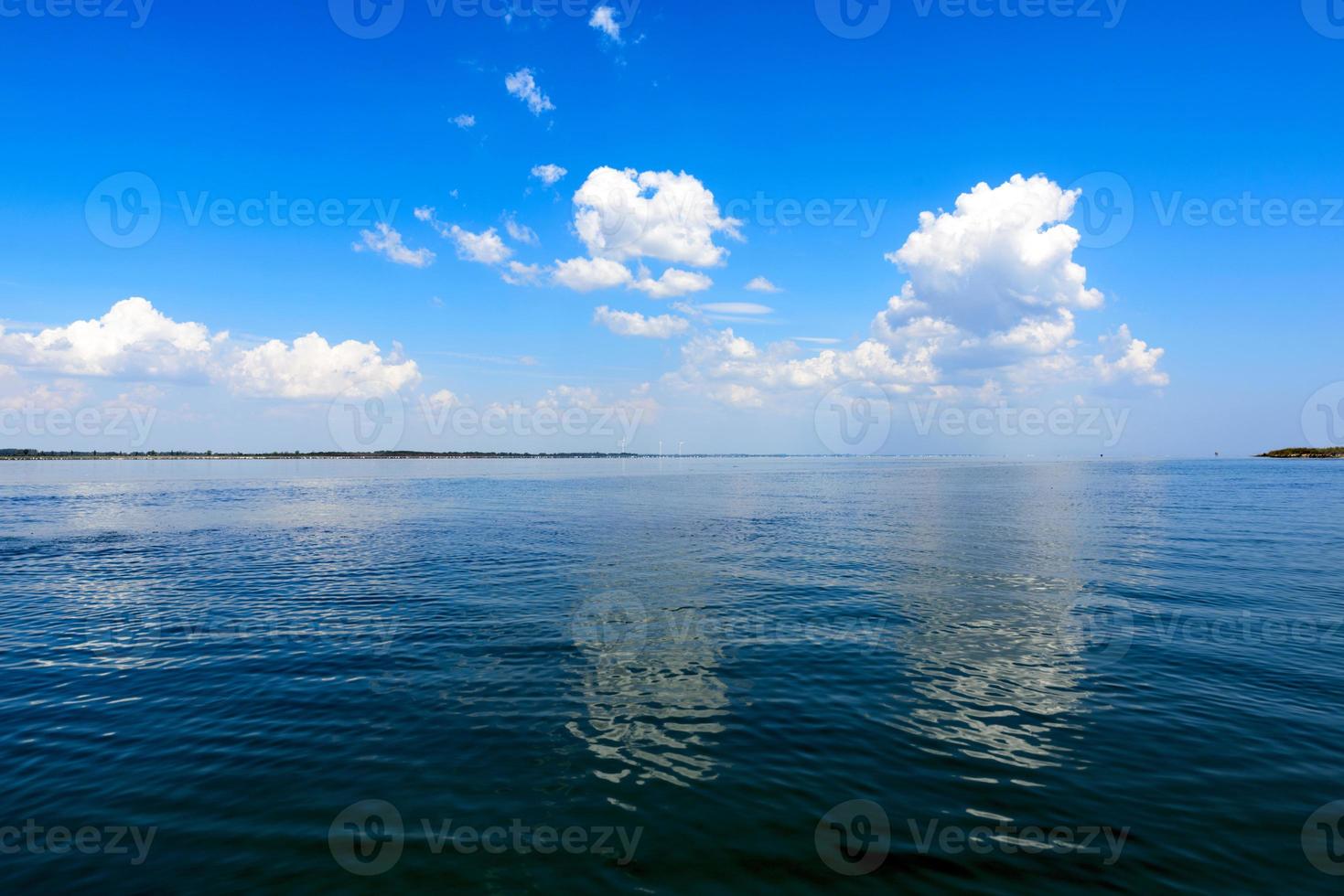 view of the sea with white fluffy clouds photo