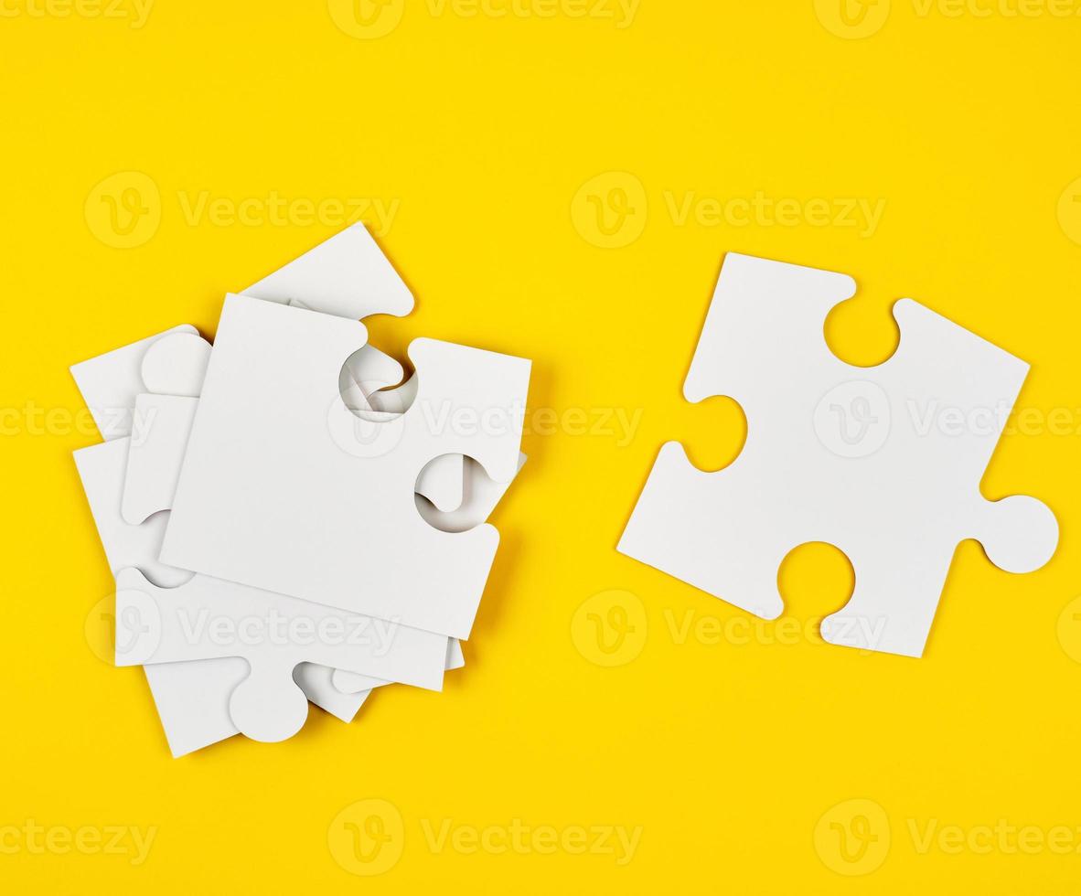 blank white big puzzles on yellow background photo