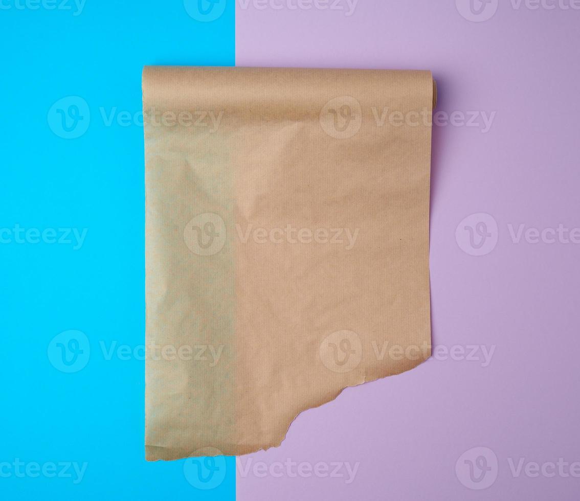 unwrapped a roll of brown parchment paper on a colored background photo