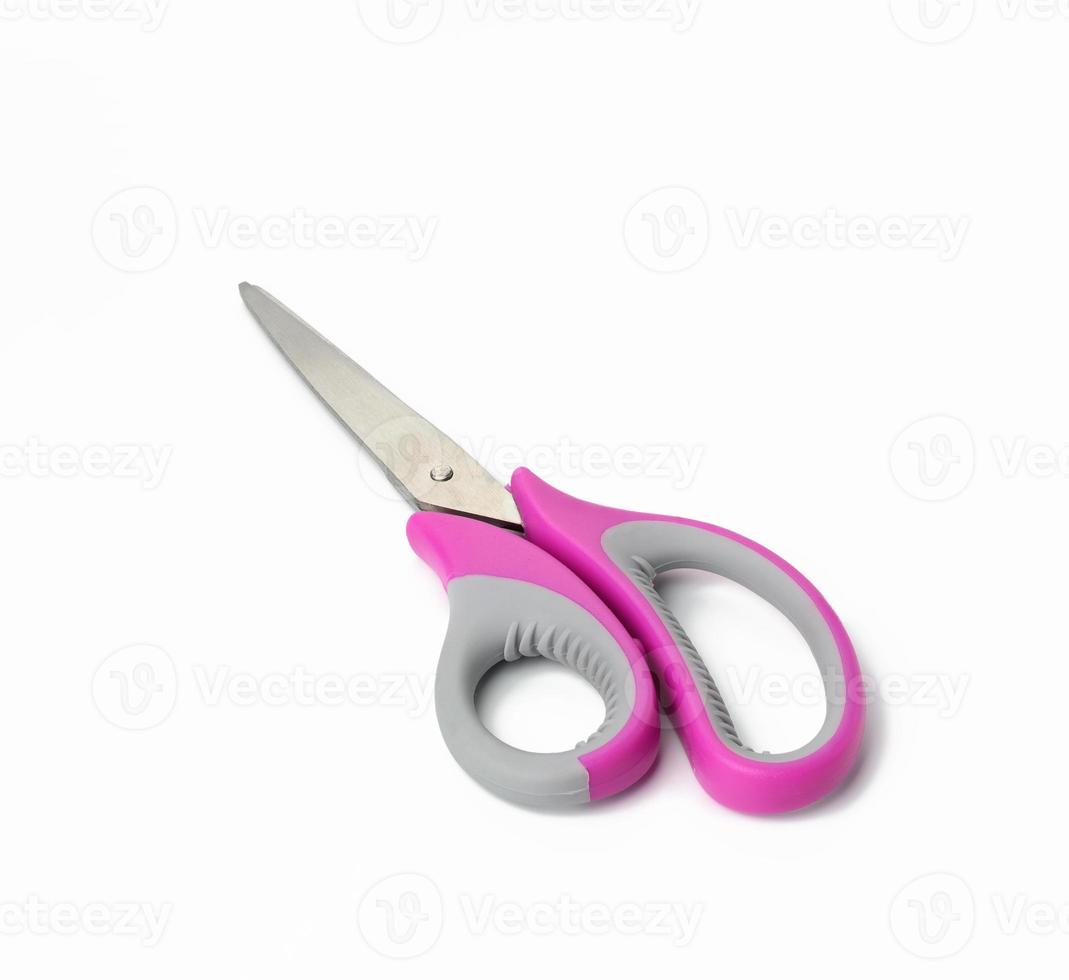 metal scissors with pink plastic handle for paper isolated on white background photo