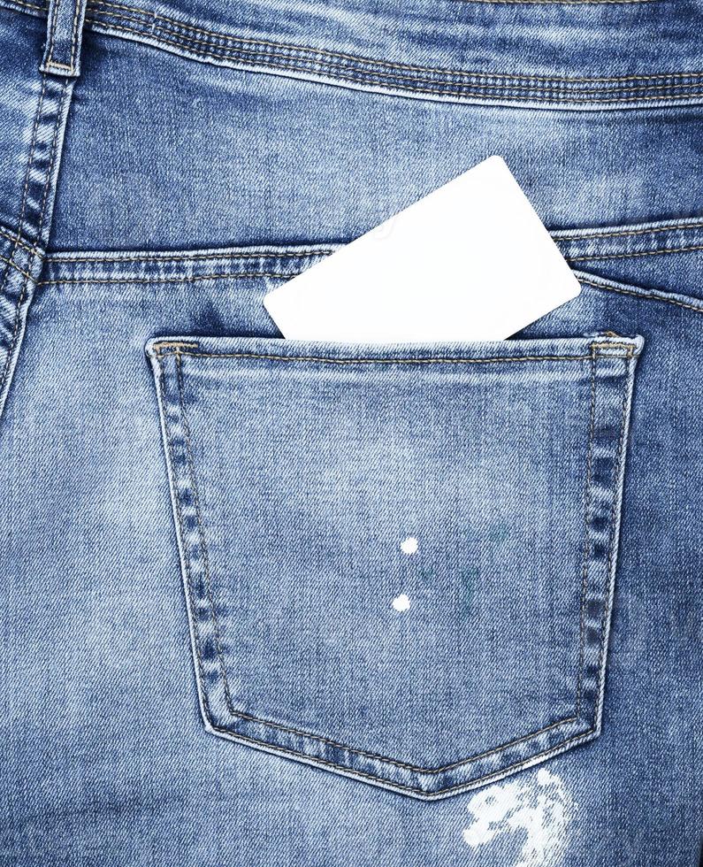 tarjeta de papel blanco vacía en el bolsillo verde de los jeans azules foto