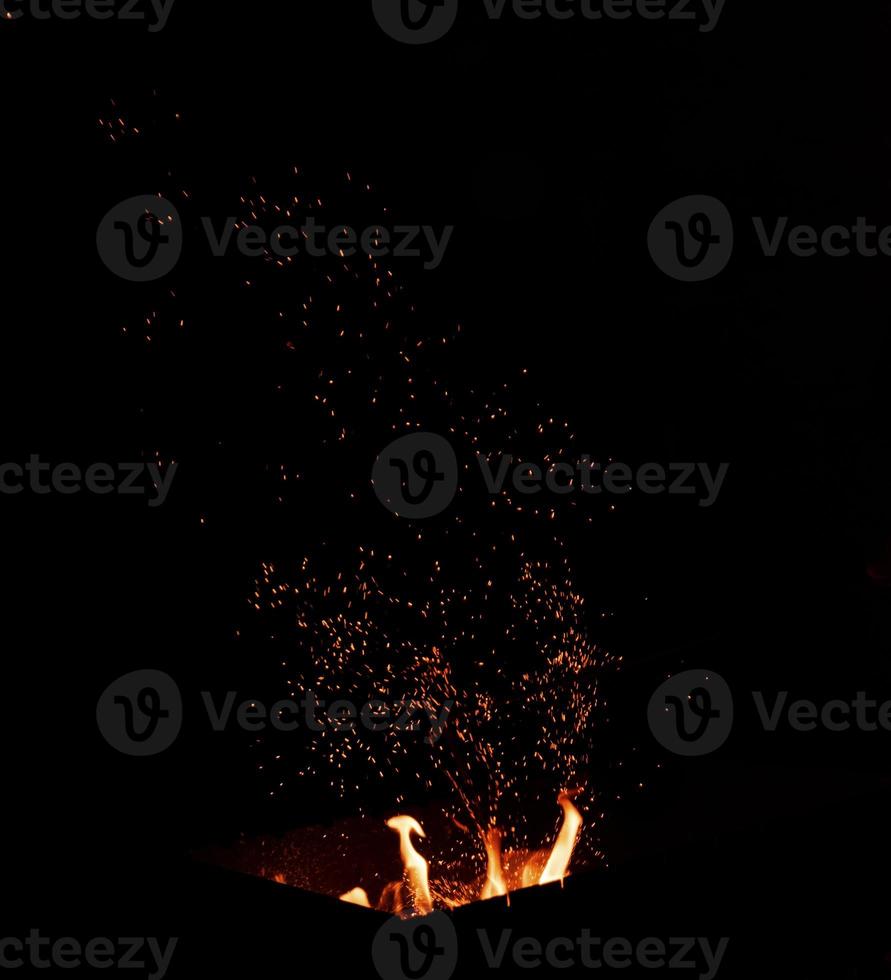 burning fire with a rising column of orange and yellow sparks photo