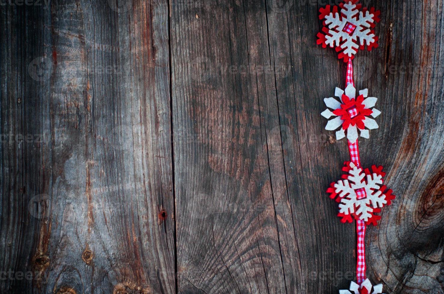 Felt snowflakes on a red ribbon to the left the empty space photo