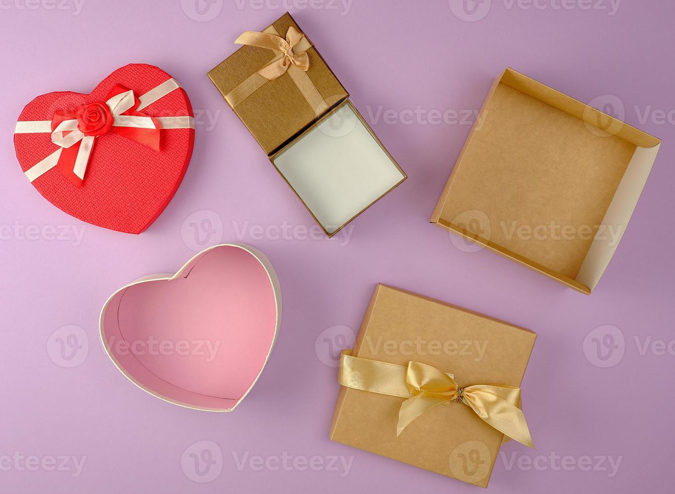 various empty open paper gift boxes on purple background photo