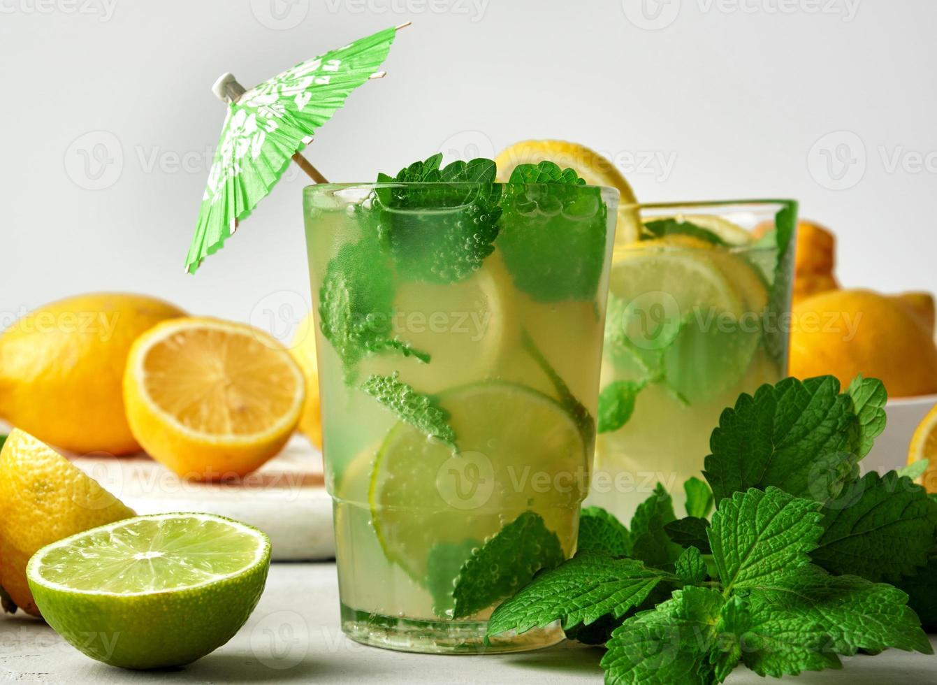 summer refreshing drink lemonade with lemons, mint leaves, lime in a glass photo