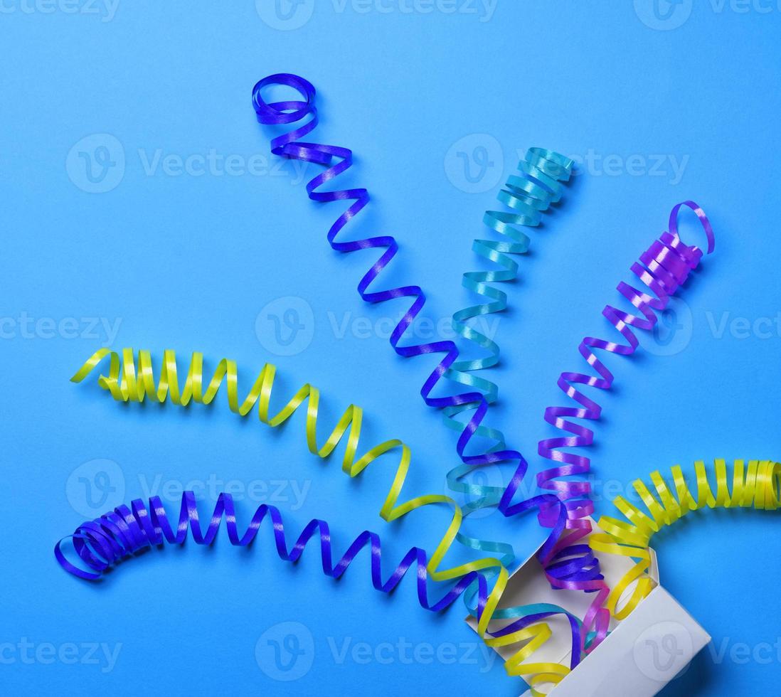 Multicolored paper serpentine shot from a white paper box photo