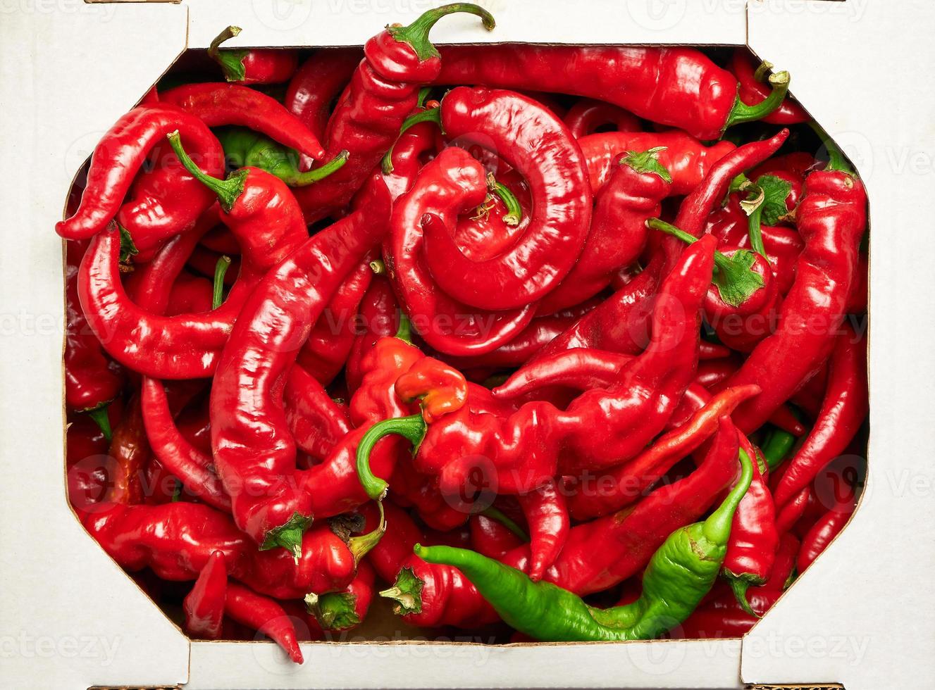 ripe red hot pepper in a white cardboard box photo