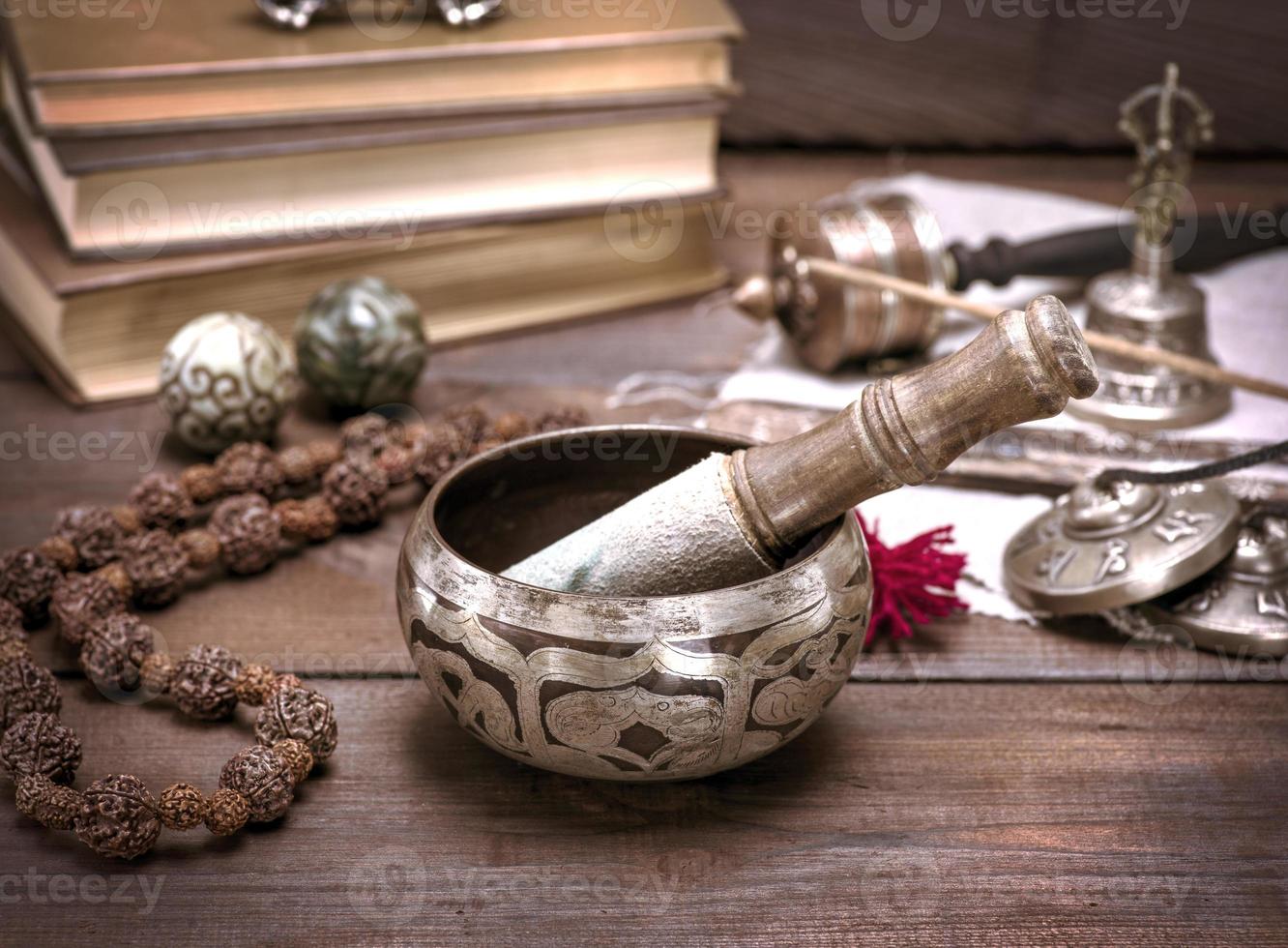 a copper singing bowl and a wooden stick photo