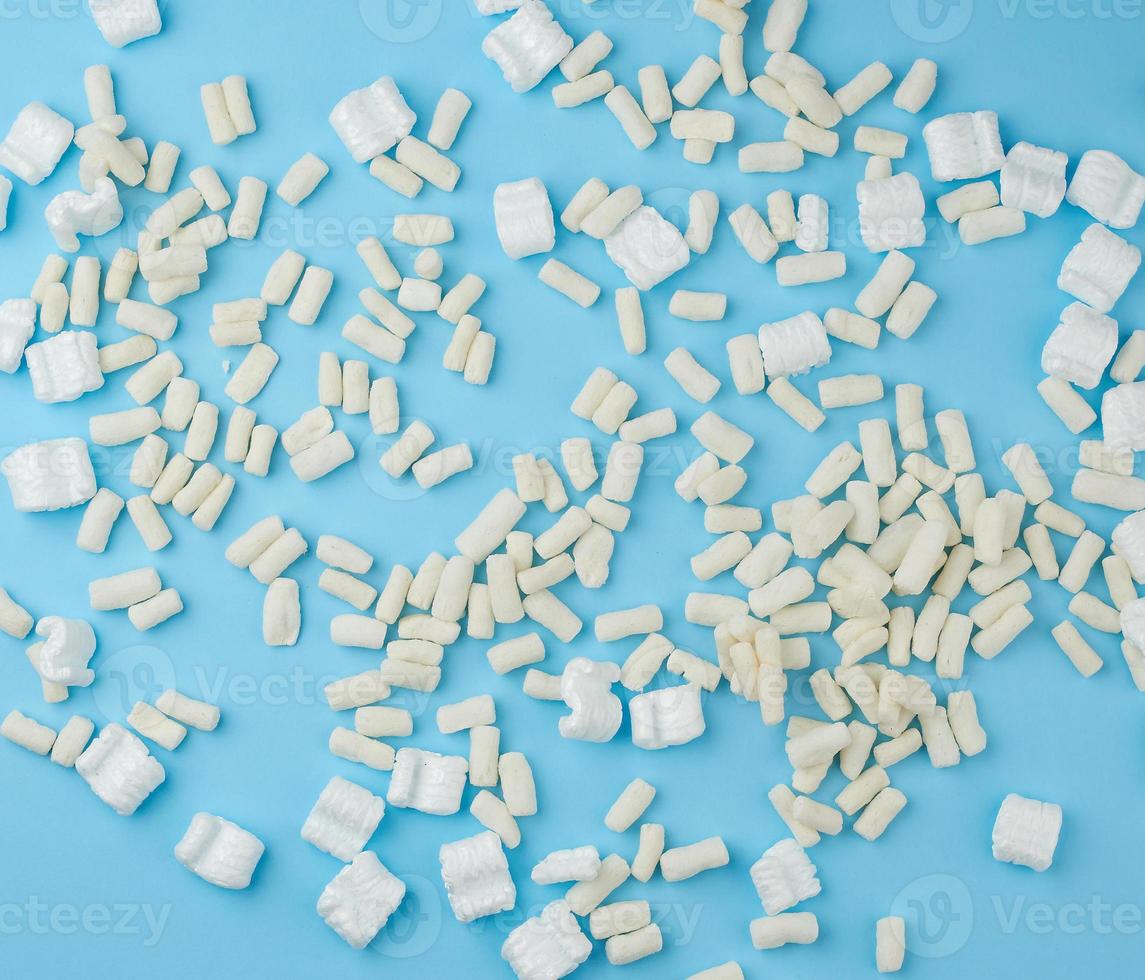 scattered white foam for packaging parcels on a blue background photo