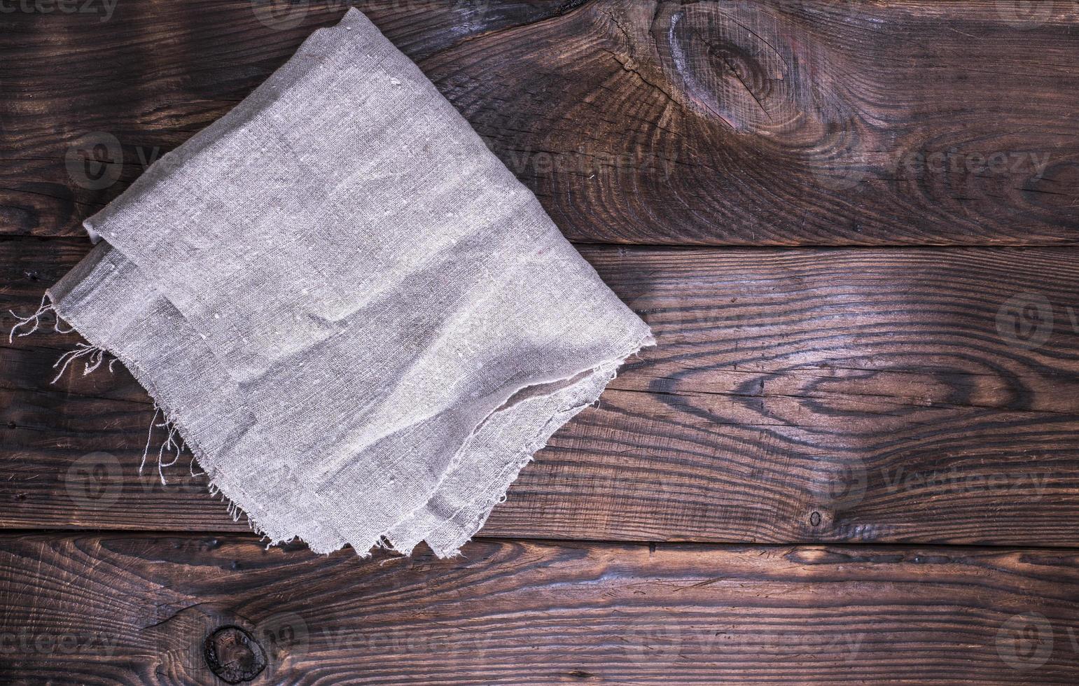 gray linen napkin on a brown wooden background photo