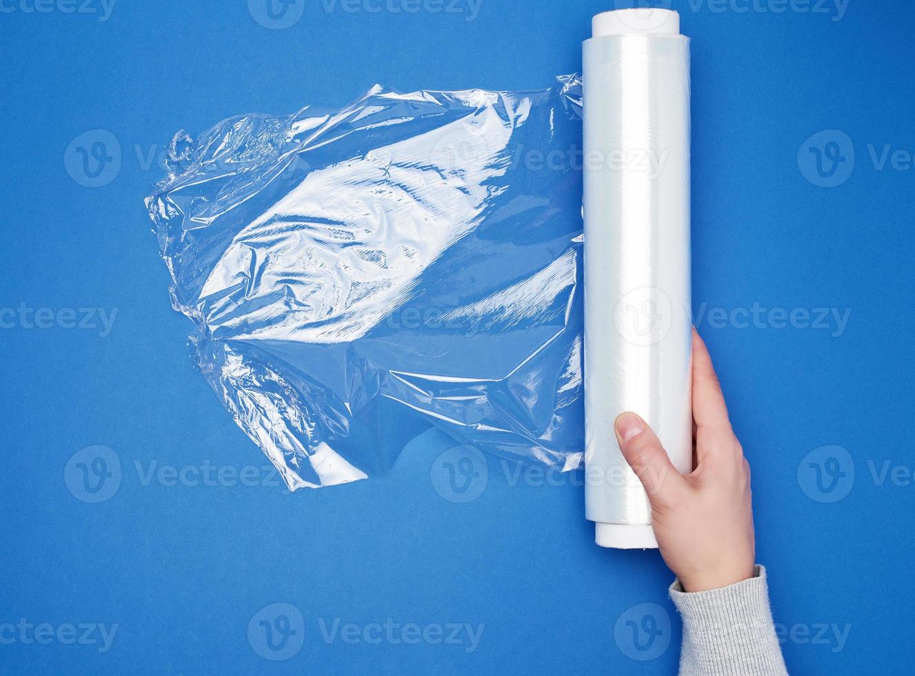 hand hold a large roll of wound white transparent film for wrapping food photo