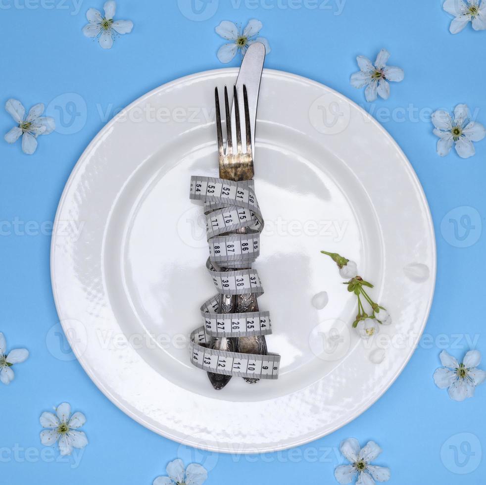 a fork with a knife wrapped in a measuring tape photo