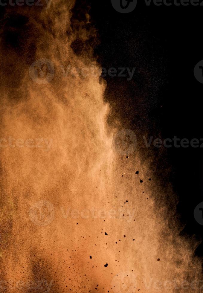 partículas de cacao marrón voladoras sobre un fondo negro. el polvo vuela foto