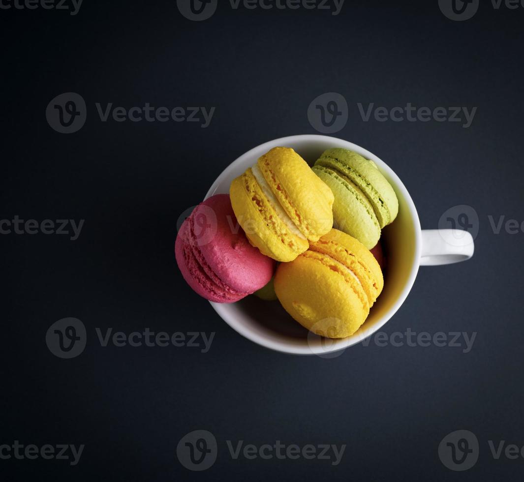 cakes of almond flour macarons in a white ceramic cup photo