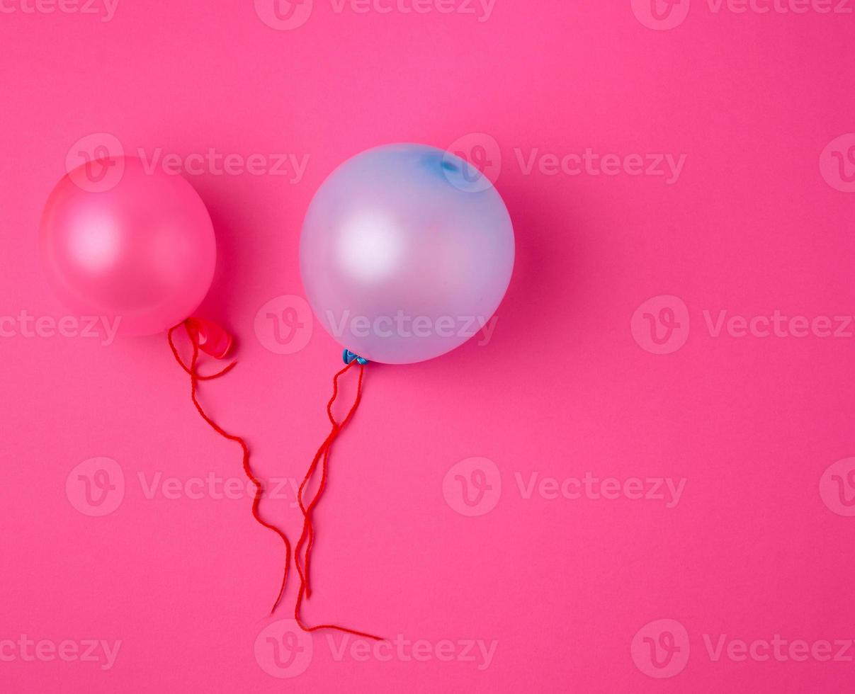 inflated blue and pink rubber balloons on a pink background photo