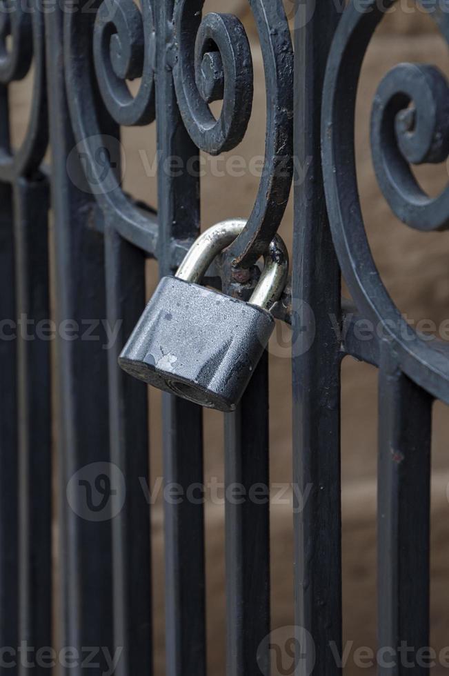 Iron lock on the black forged fence photo