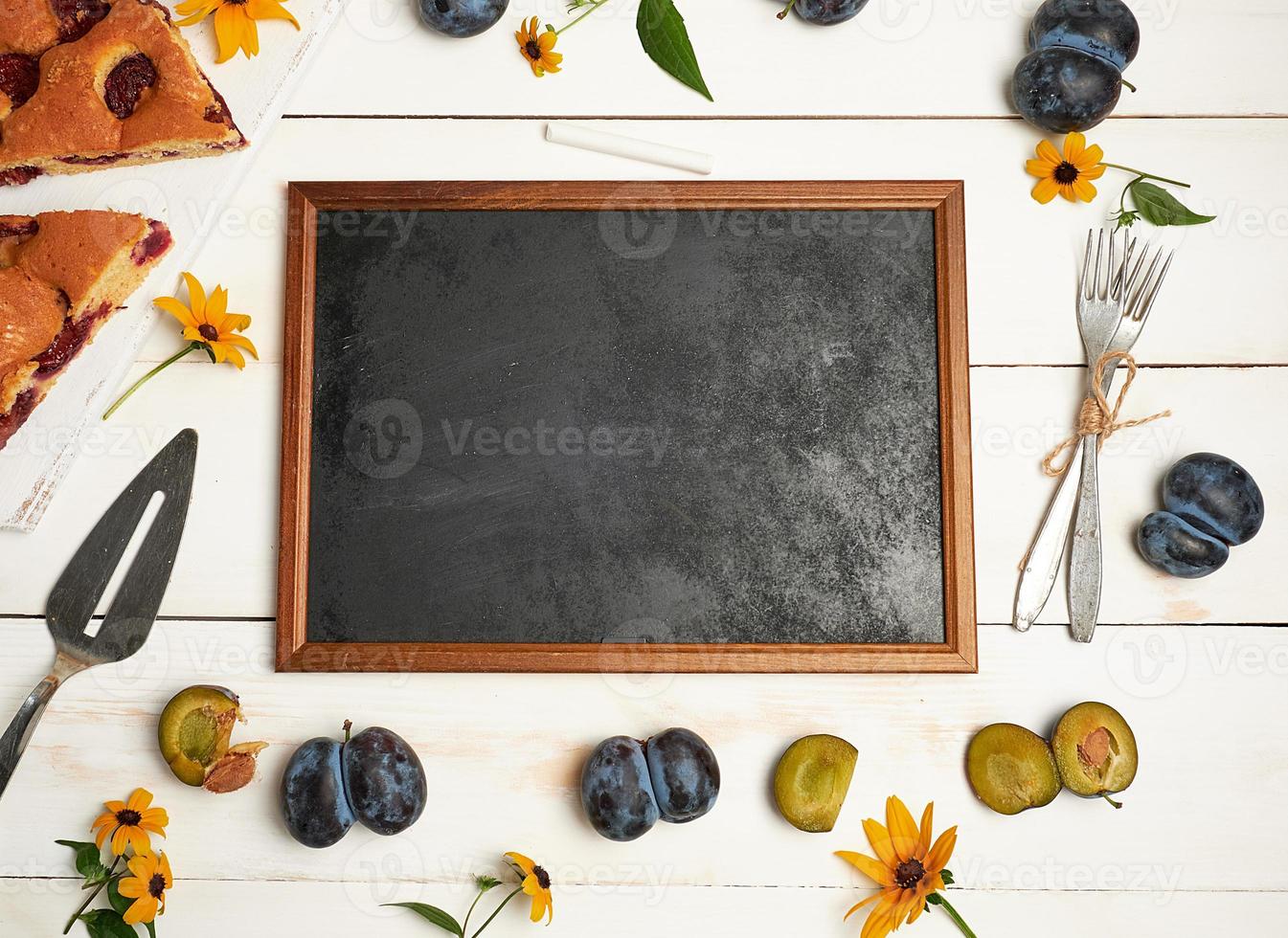 empty chalky black frame ingredients and slices of plum cake photo