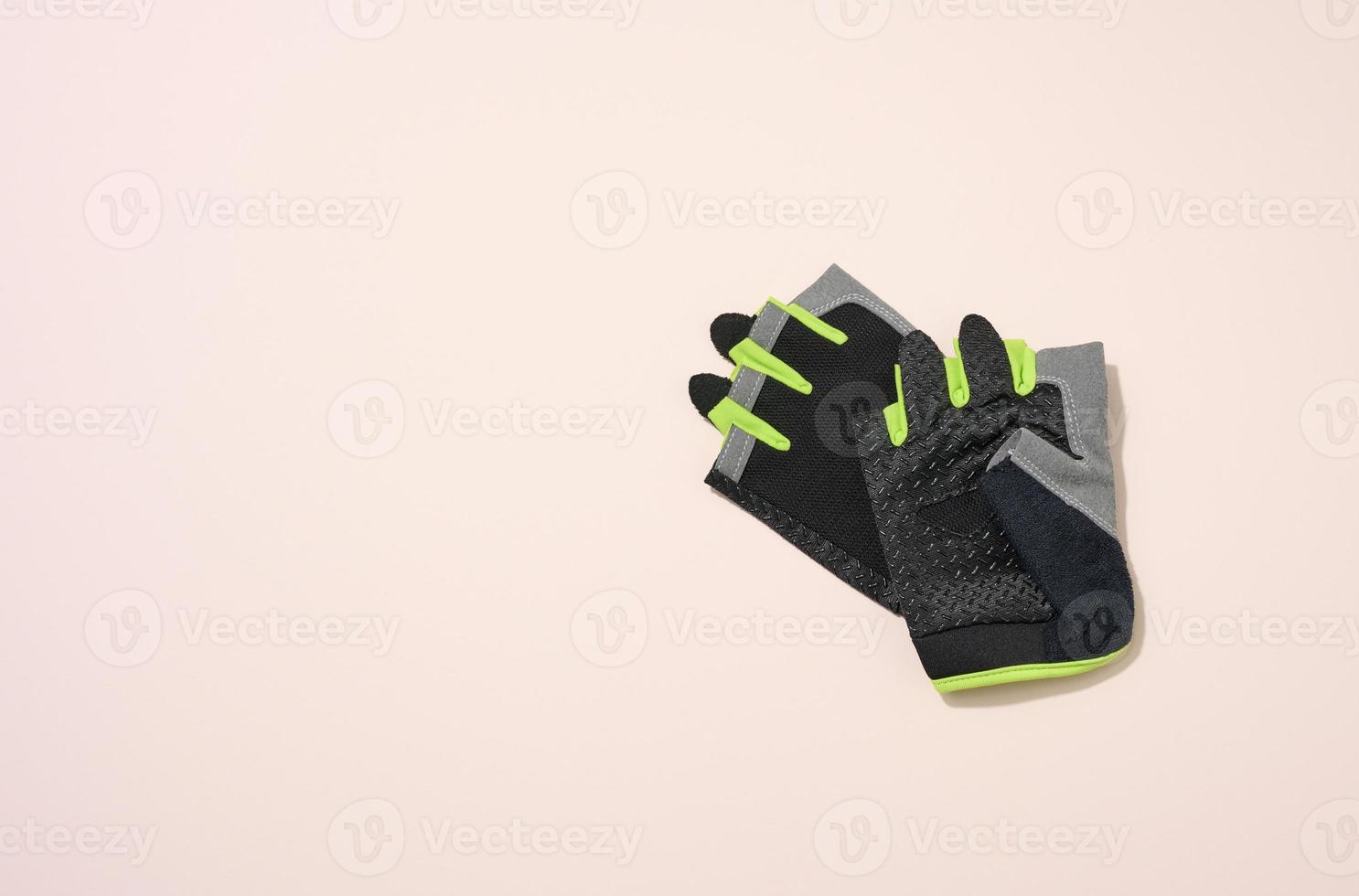 pair of black sports gloves for doing sports and riding bike on a beige background photo