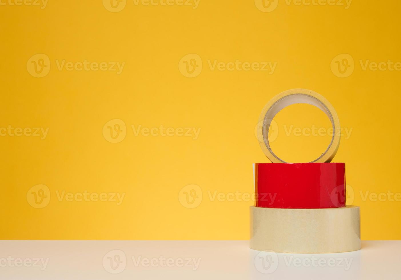 Rolls of adhesive tape on a yellow background photo