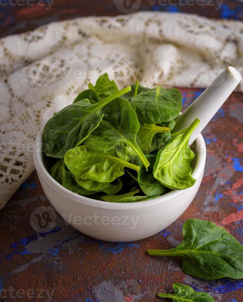 fresh green spinach leaves in a white ceramic mortar photo