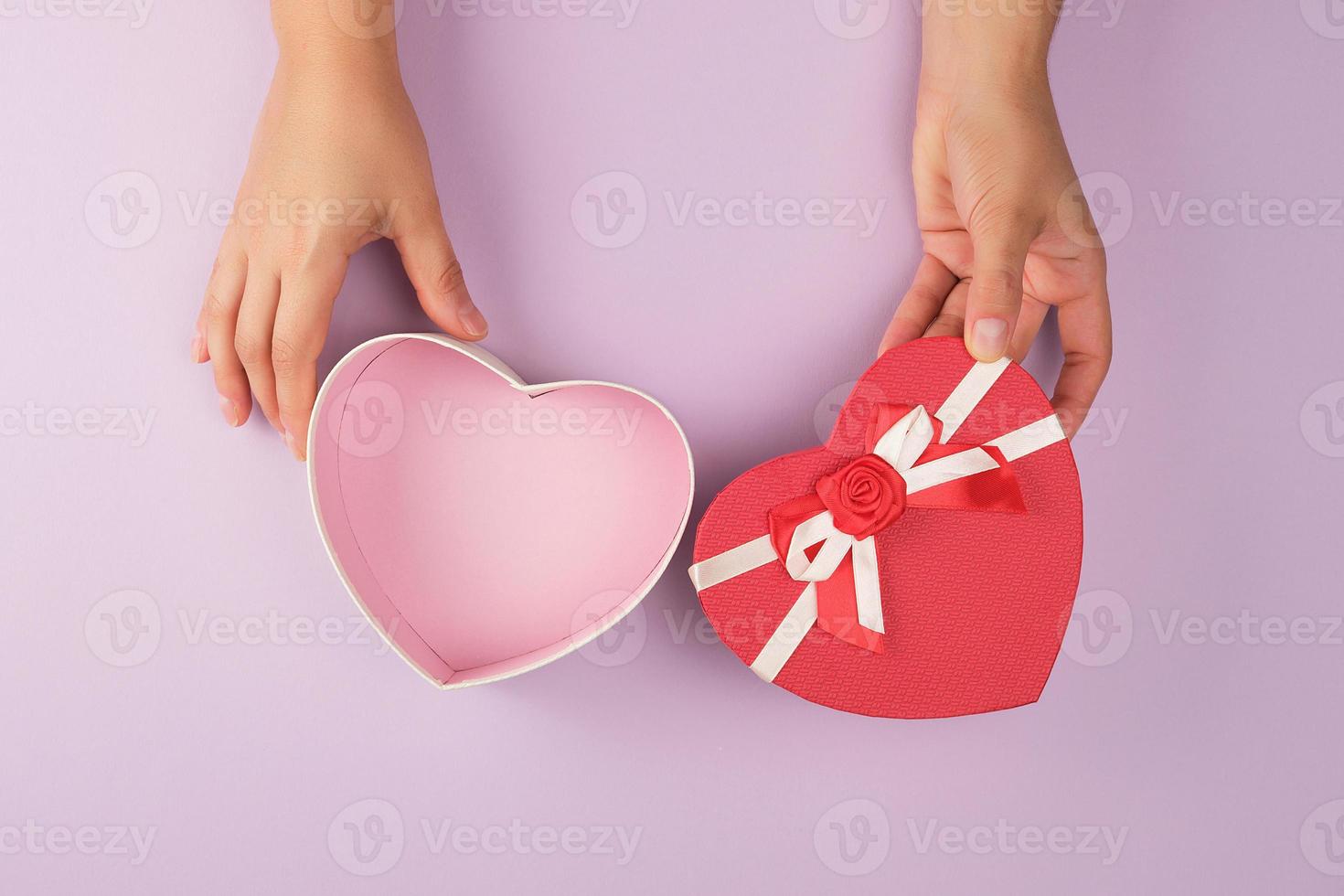 two female hands holding an open desert red heart-shaped box photo