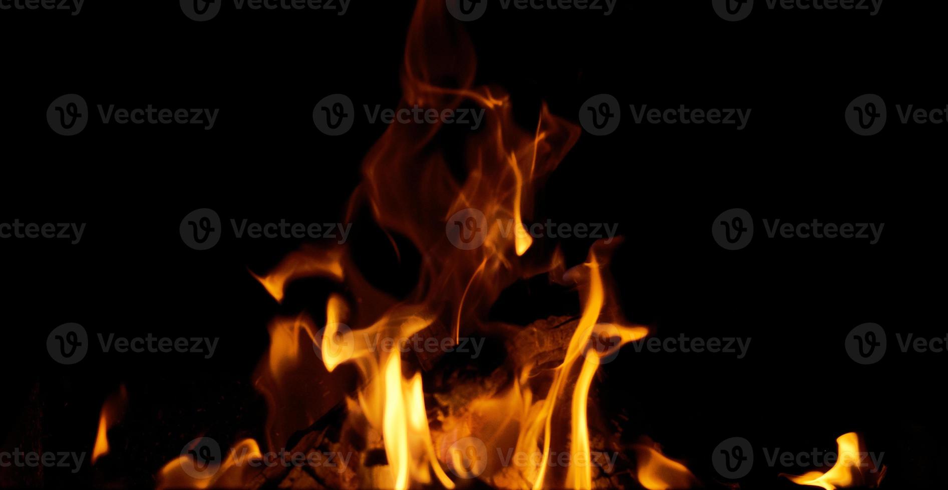 bright orange and yellow flames with sparks on black background photo