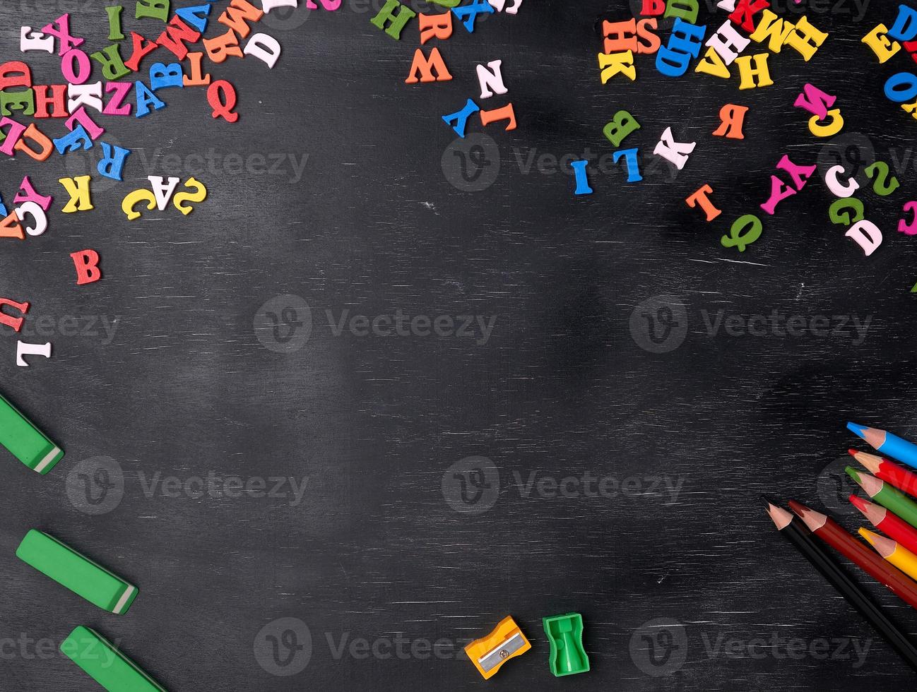 multicolored small wooden letters of the English alphabet on a black chalk board photo