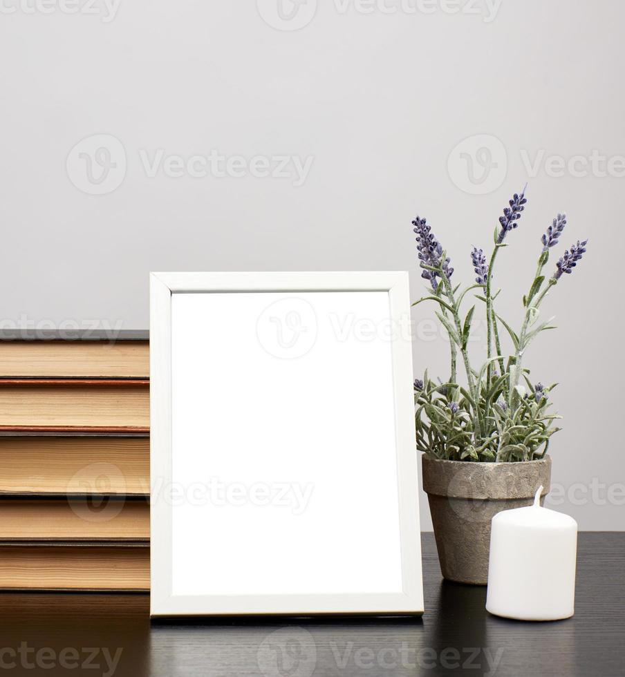 empty white photo frame, stack of books