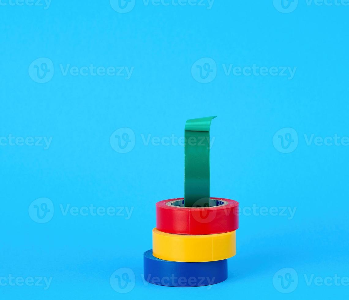 full coils of multi-colored insulating tape on a blue background photo