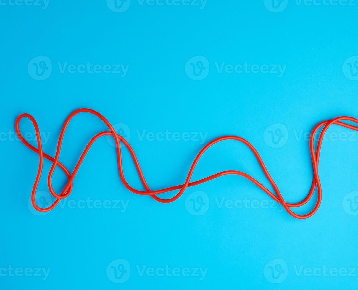 fragment of a red jump rope for sports on a blue background photo