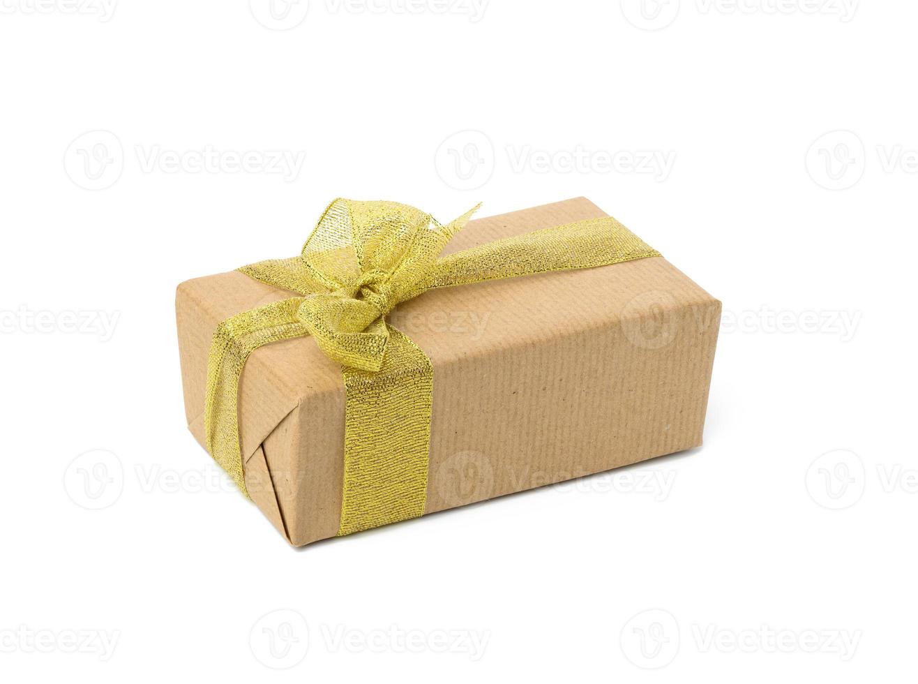 rectangular box wrapped in brown kraft paper and golden ribbon. photo