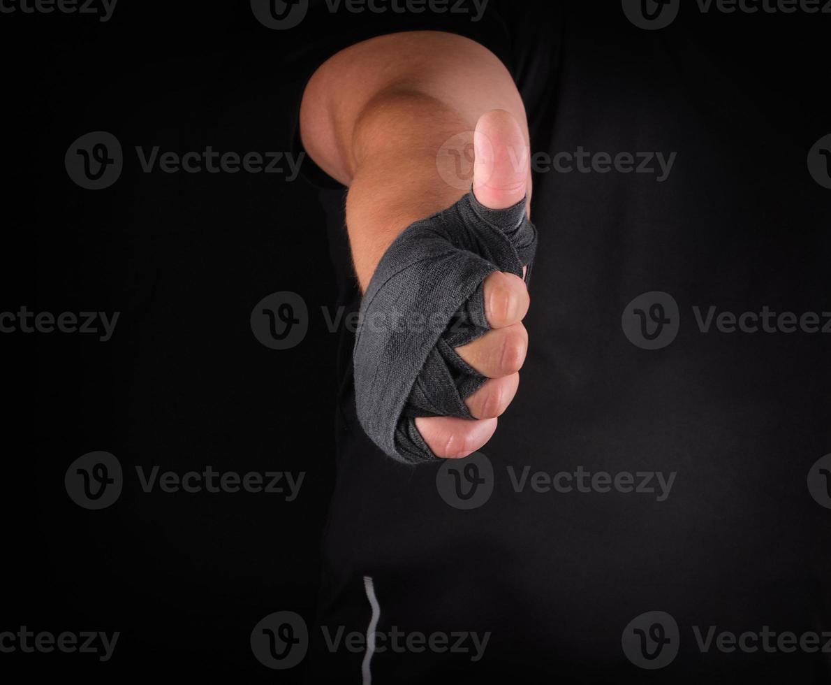sportsman's hands wrapped in black elastic sports bandage show a like sign photo