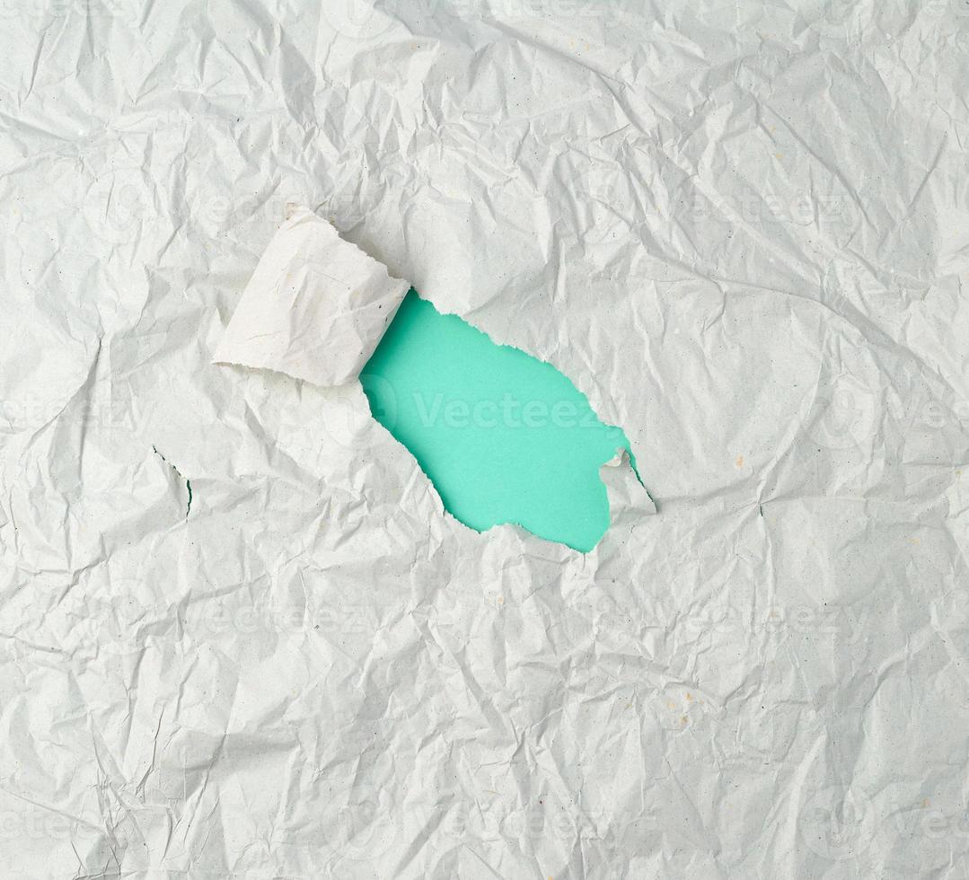 gray crumpled sheet of paper with a hole, green backing photo