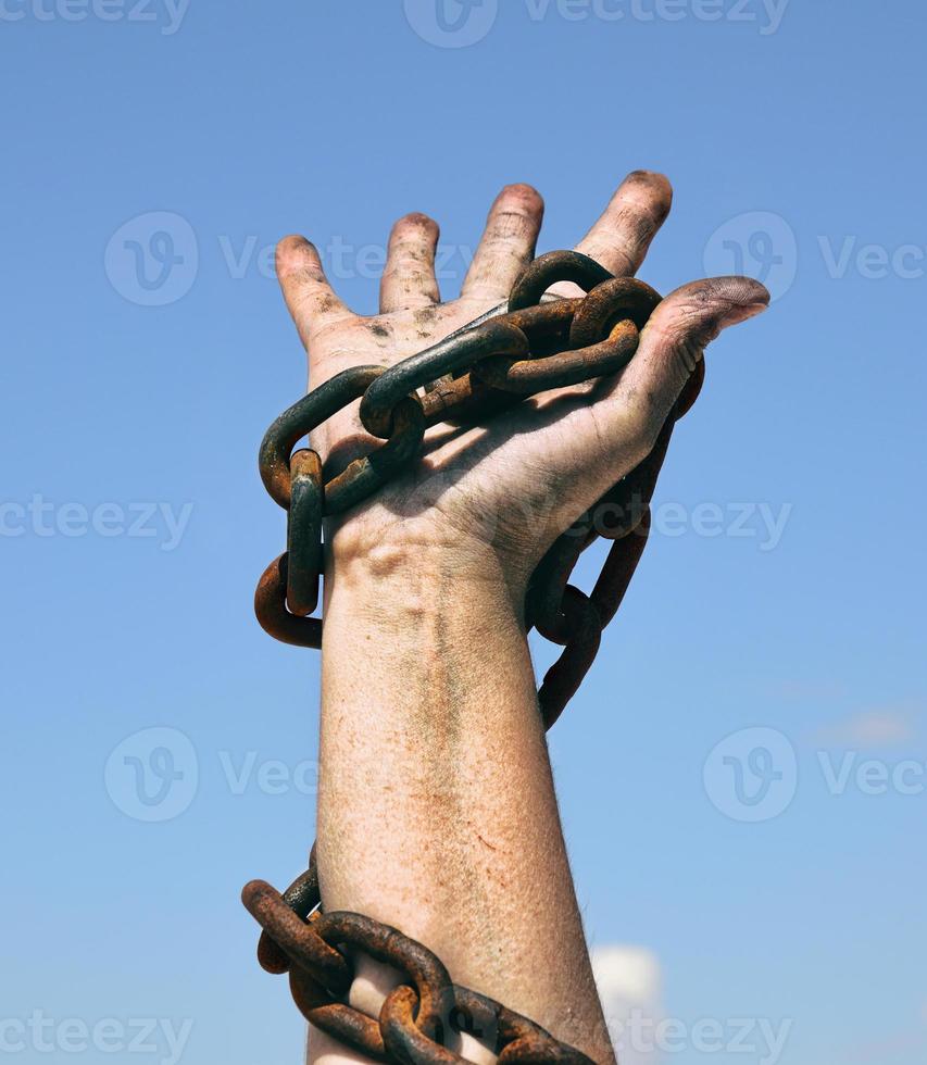right female hand holds a rusty chain photo