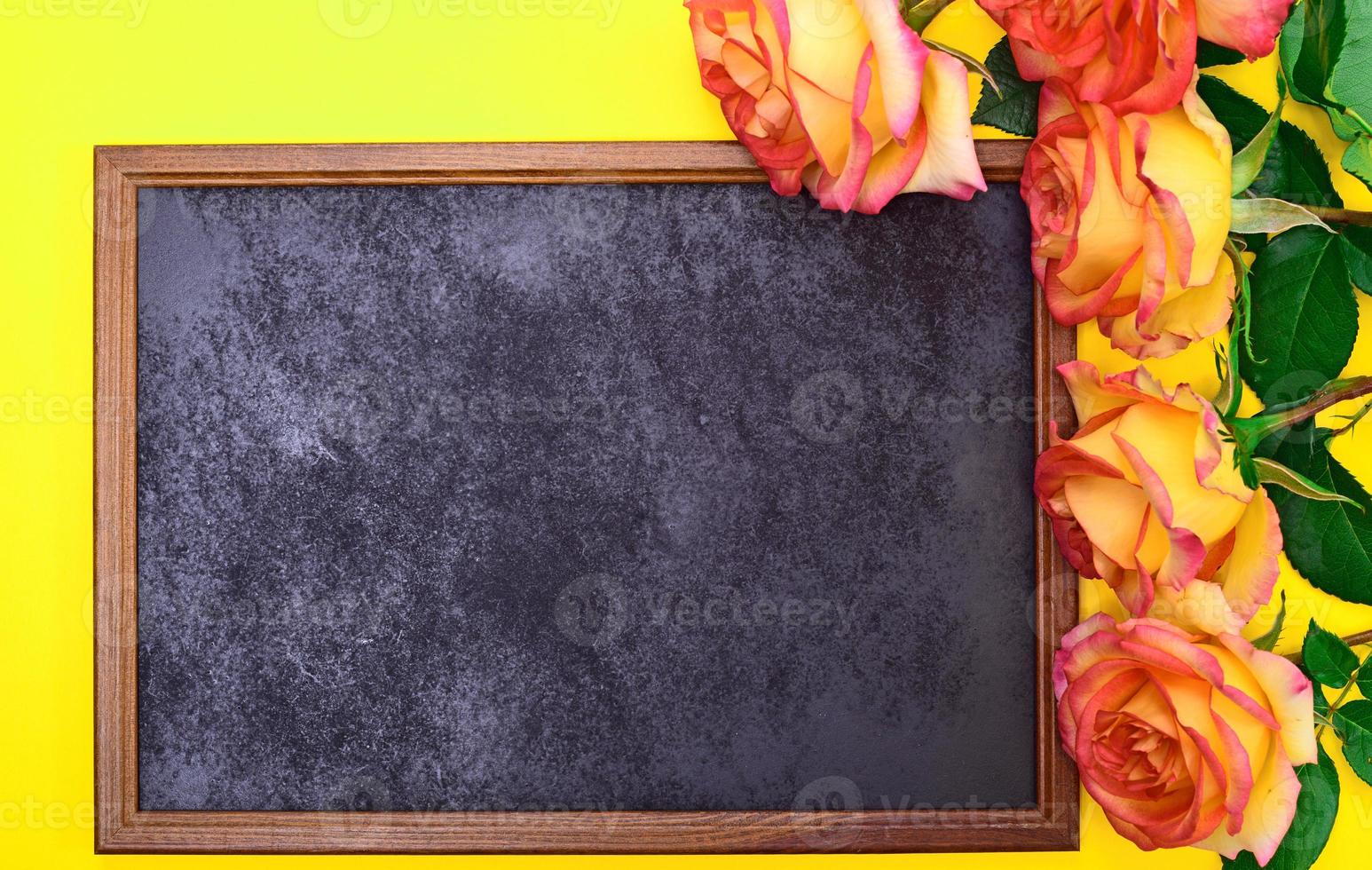 Empty black frame with a bouquet of yellow roses photo