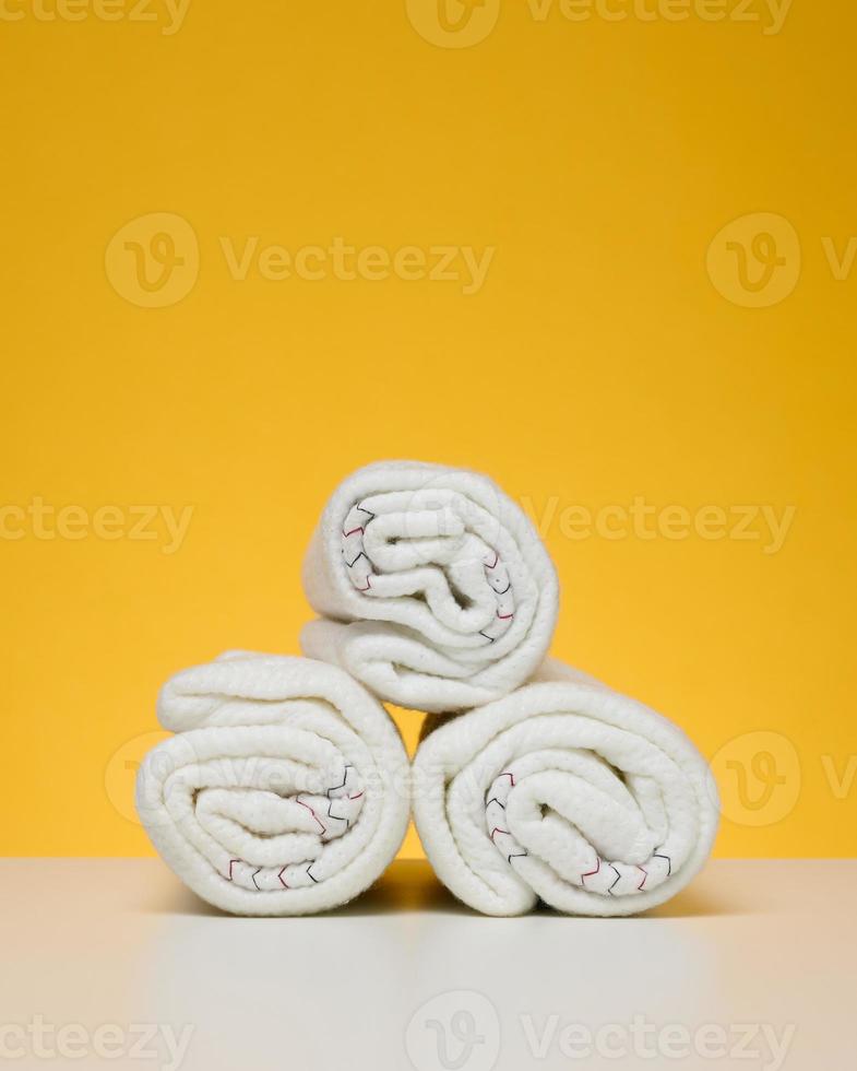 Twisted white rags for mopping on a yellow background photo