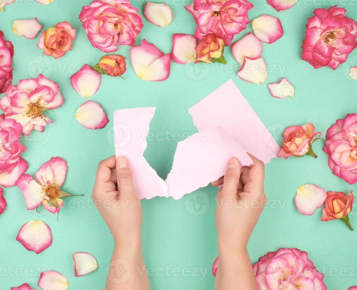 two hands hold an empty pink sheet torn from a notebook photo