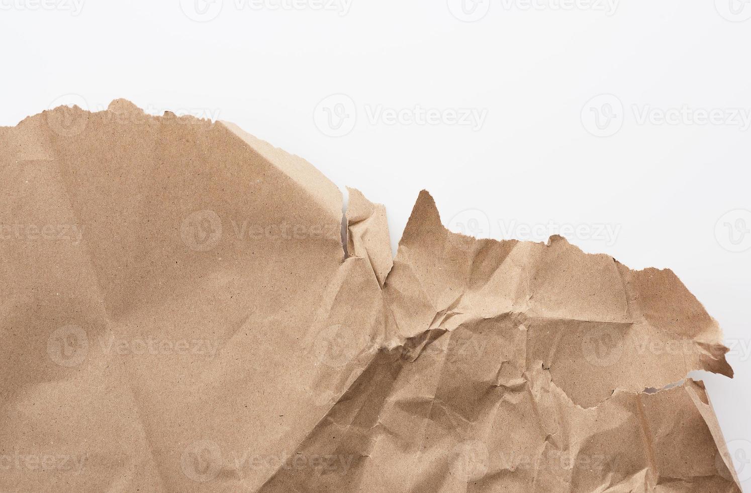 fragment of a crumpled blank sheet of brown wrapping kraft paper with torn edges photo