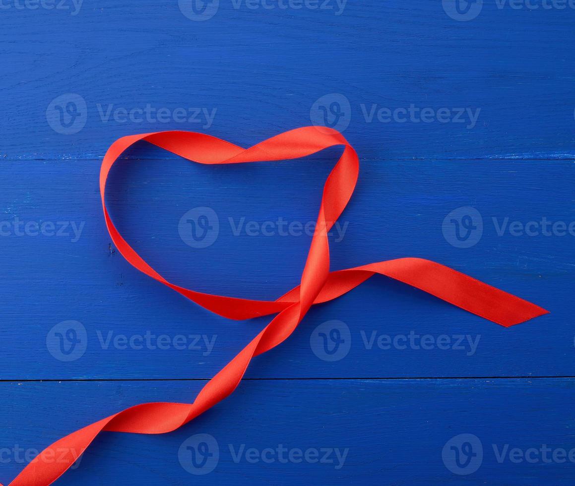 twisted silk ribbon on a blue wooden background photo