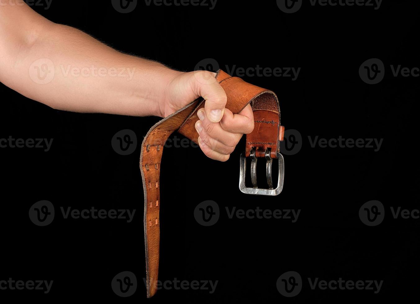 cinturón de cuero marrón con hebilla de hierro en la mano de un hombre foto