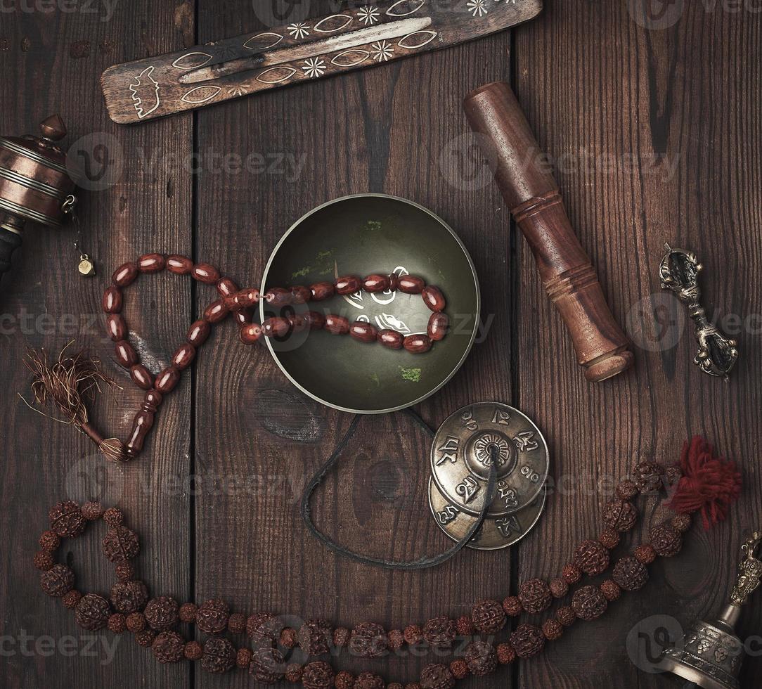 Copper singing bowl, prayer beads, prayer drum and other Tibetan religious objects for meditation and alternative medicine photo