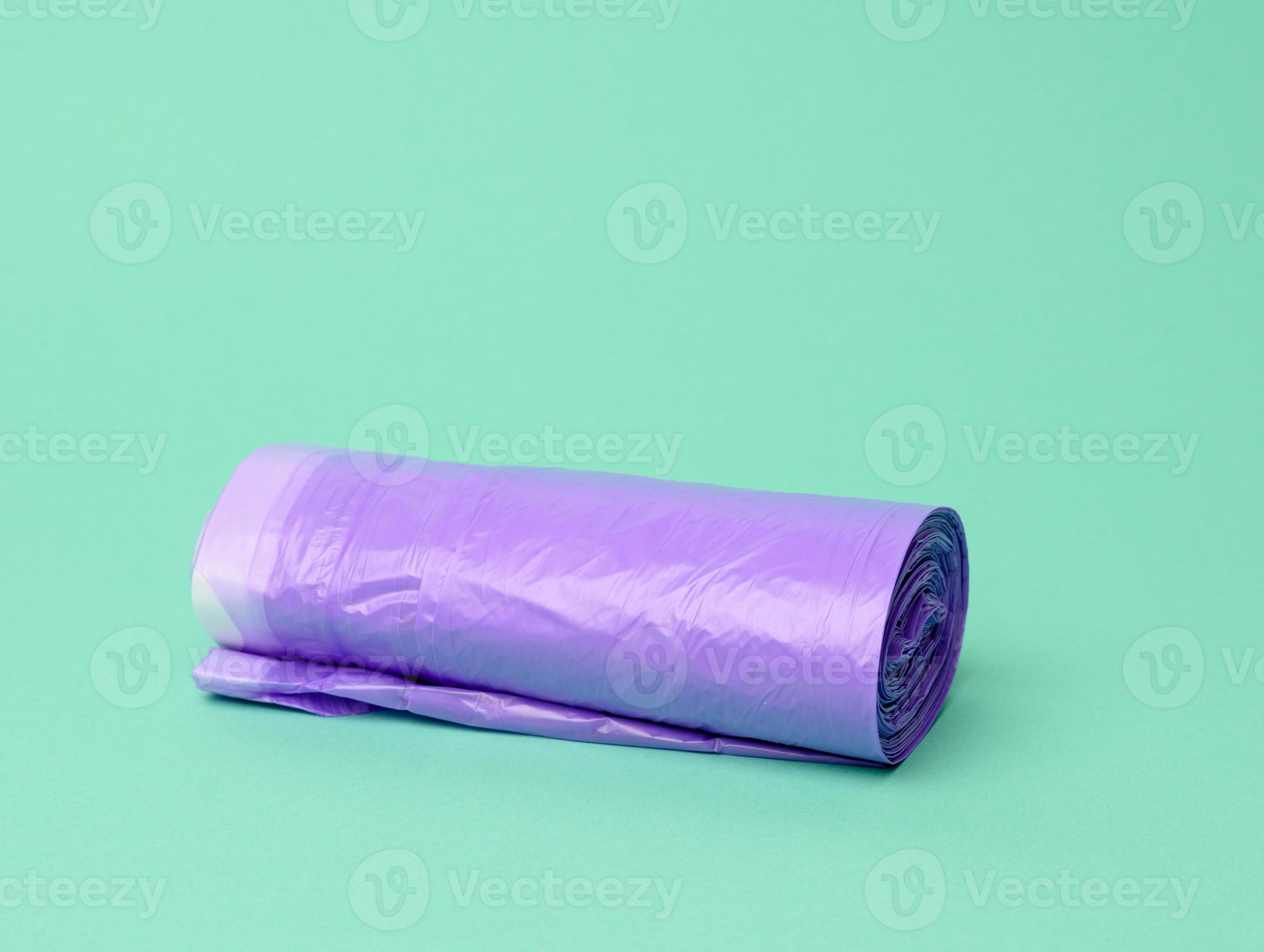 skein of purple plastic trash bags with strings on a green background