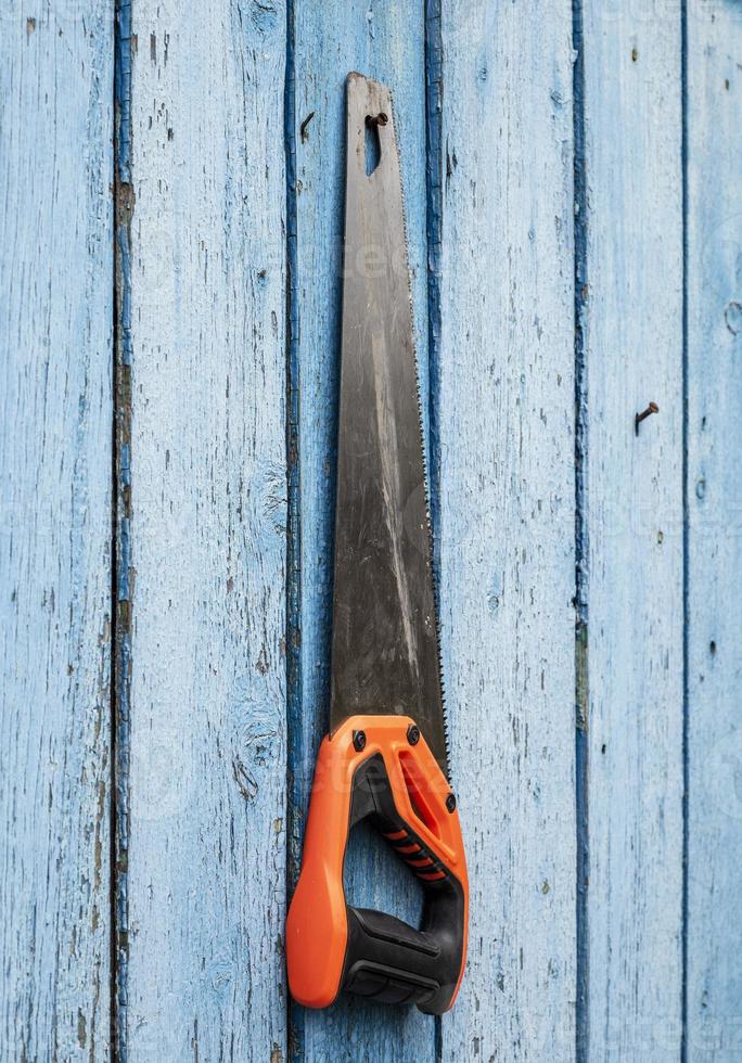 Hand saw for wood hanging from a nail photo