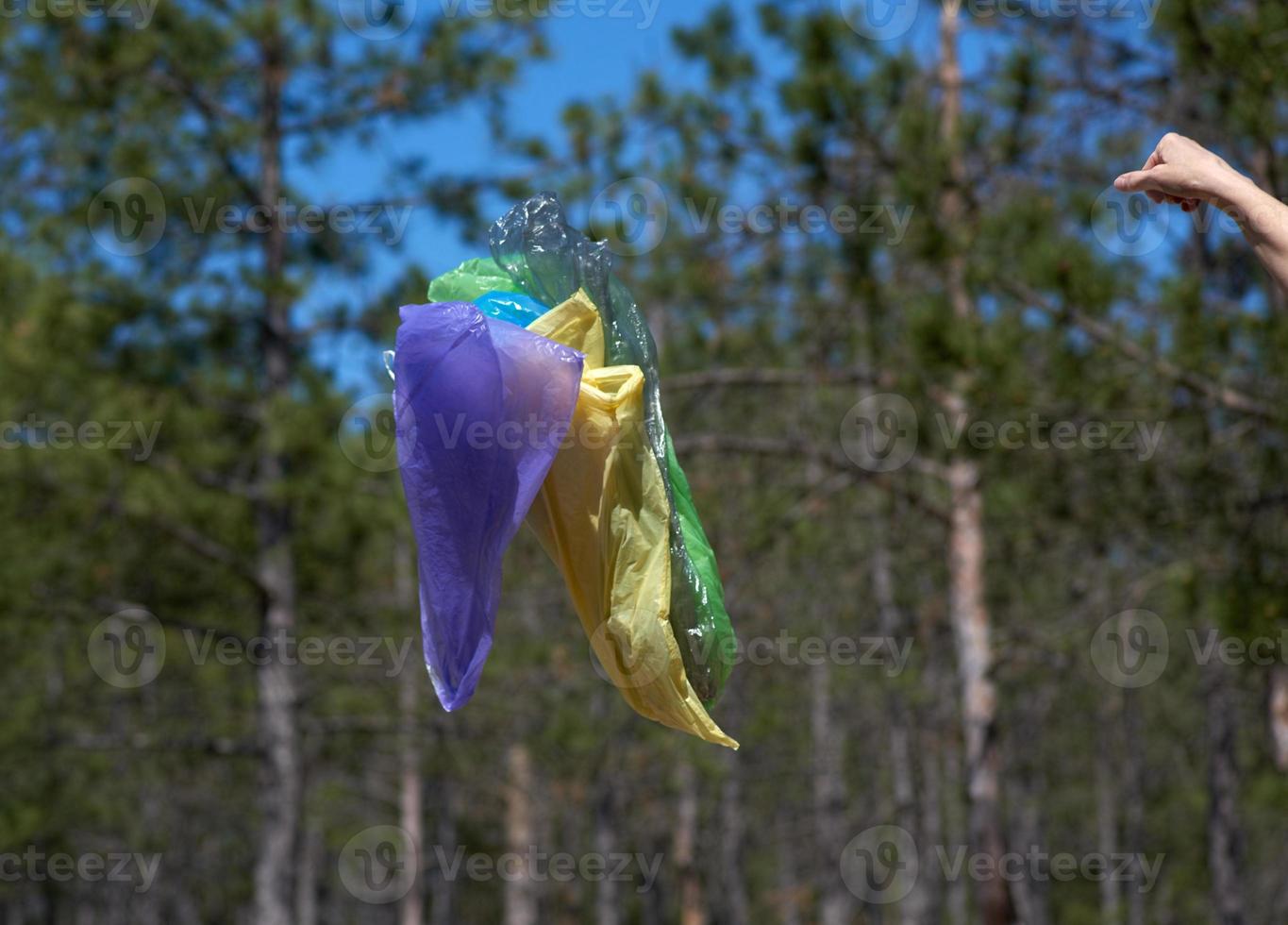 empty garbage plastic bags fly in the forest on a summer day photo